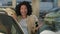 African American girl client buyer customer driver buying new electric automobile in auto showroom. Portrait of happy