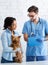 African American girl with cute dog on visit to veterinarian doctor at clinic