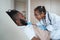 African American girl in a medical gown looks into the mouth of a lying father