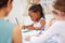 African american girl sitting at a table and colouring at pre-school or kindergarten with her fellow students. Young