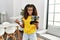 African american girl smiling confident holding drone at home