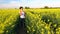 African American girl teenager female young woman hiking with red backpack and bottle of water in field of yellow flower