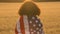 African American girl teenager female young woman holding an American USA Stars and Stripes flag in a wheat field at sunset or sun