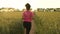 African American girl teenager female young woman runner running on path through field of barley or wheat crops at sunset