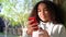 African American girl teenager leaning against a tree using cell phone