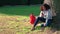 African American girl teenager sitting by a tree with a red backpack and using a cell phone for social med