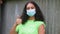 African American girl teenager young woman wearing a face mask showing her vaccine sticking plaster giving thumbs up