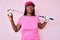 African american golfer woman with braids holding golf ball smiling looking to the side and staring away thinking