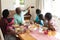 African american grandfather taking selfie with grandchildren and their parents at family meal