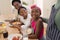 African american grandparents cooking with smiling grandson and granddaughter in kitchen