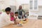 African american grandparents cooking with smiling grandson and granddaughter in kitchen