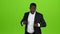 African american guy dances in a business suit, he has funny moves. Green screen. Slow motion