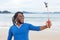 African american guy with dreadlocks taking selfie at beach