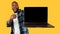 African American Guy Showing Laptop Blank Screen Over Yellow Background
