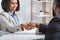 African American hiring manager shaking hand of vacancy candidate during employment interview in office