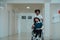 African-American hospital technician compassionately navigating the hospital hallways, pushing his wheelchair-bound