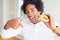 African American hungry man eating hamburger for lunch with surprise face pointing finger to himself