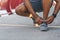 African american jogger checking on his shoelaces on bridge