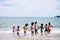 African American, Kids group in swimwear enjoying running to play the waves on beach. Ethnically diverse concept. Having fun after