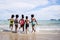 African American, Kids group in swimwear enjoying running to play the waves on beach. Ethnically diverse concept. Having fun after