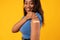 African American Lady Showing Vaccinated Arm, Yellow Studio Background, Cropped