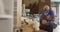 African american male carpenter with digital tablet choosing wooden plank in a carpentry shop