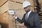 African American male contractor using tablet PC while inspecting wooden planks