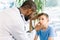 African American male doctor testing patient`s eye of a little boy in clinic. Medical examination concept