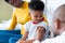 African american male doctor vaccinating boy patient, with mother in hospital