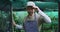 African american male gardener taking off cap and looking at camera at garden center