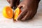 African American Male Hand slicing oranges on white marble tray. Healthy Citrus Fruit