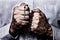 African American male hands praying holding a beads rosary with Jesus Christ in the cross or Crucifix