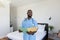 African american male health worker holding a file standing in bedroom at home