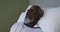 African american male patient lying in hospital bed and yawning