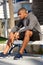 African american male runner sitting outdoors on bench