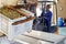 African American male worker controlling process of unloading grapes with forklift