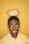 African-American man balancing bowl of popcorn on head.