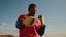 African-American man boxer in sportswear warms up and stretches muscles before training outdoor, front view. Black man