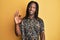 African american man with braids wearing leopard animal print shirt smiling positive doing ok sign with hand and fingers