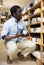 African american man choosing ceramic mugs in dishware store