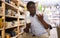 African american man choosing ceramic mugs in dishware store