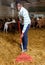 African-American man cleaning goat barn