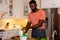 African american man composting vegetable waste in kitchen