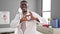 African american man doctor smiling doing heart gesture with hands at clinic