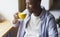 African American man drinking his moring coffee and relaxing in cafe. Panorama