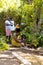 African american man and grandson watering plants while grandmother and granddaughter digging dirt