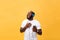 African American man with headphones listen and dance with music. Isolated on yellow background