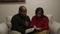 African American Man and Hispanic Woman Read Bible at Home