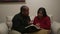 African American Man and Hispanic Woman Read Bible at Home