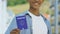 African-american man holding blue passport, migration policy, visa-free regime